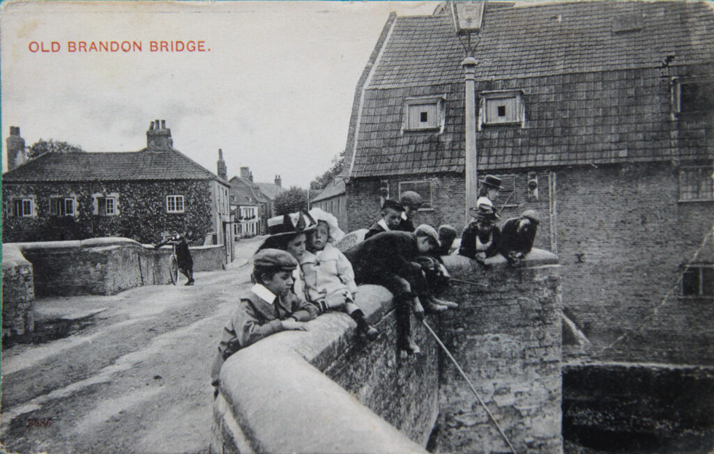 children on a bridge with maltings buildings