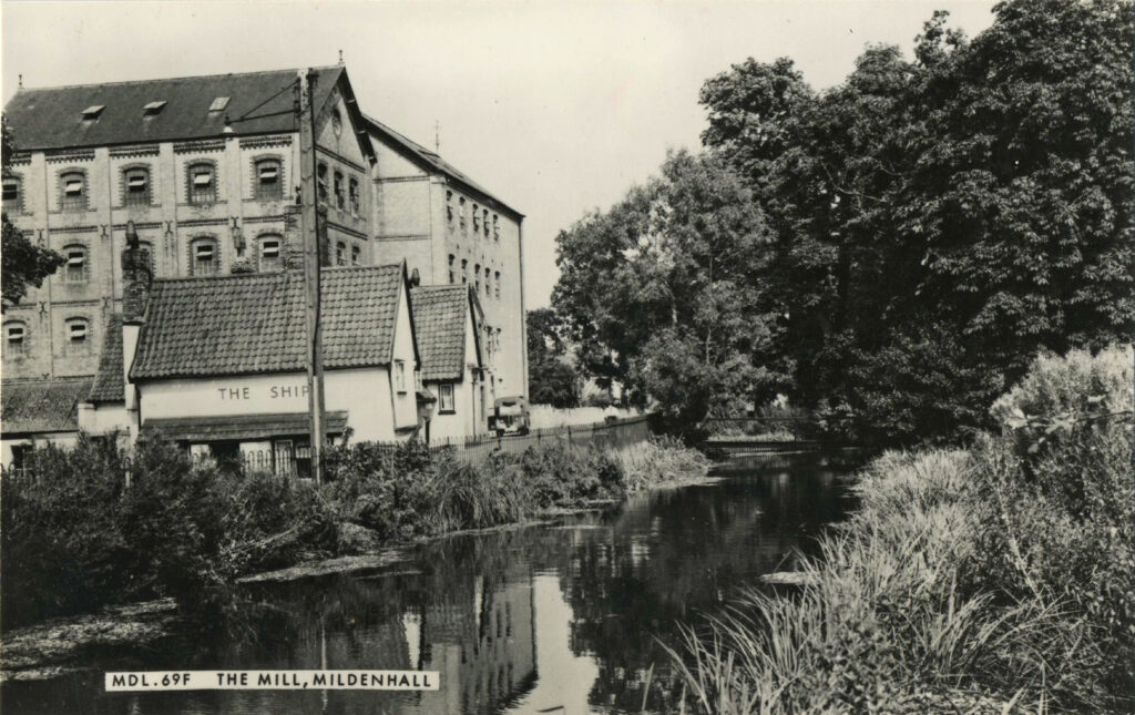 a mill and a small pub building by the river