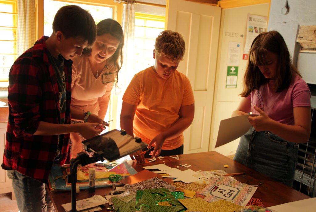 young people working on animations, cutting out paper, concentrating