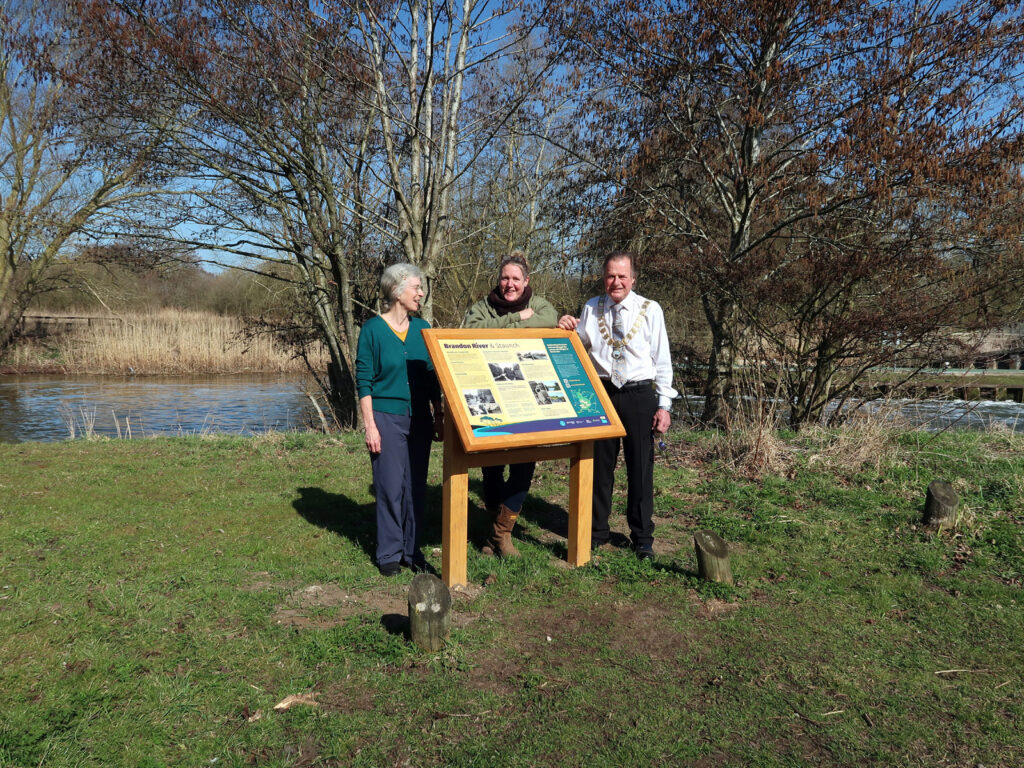 Imogen Radford, Ali Barnes, Councillor Phil Wittam, Mayor with chain, standing behind the Staunch panel, river behind