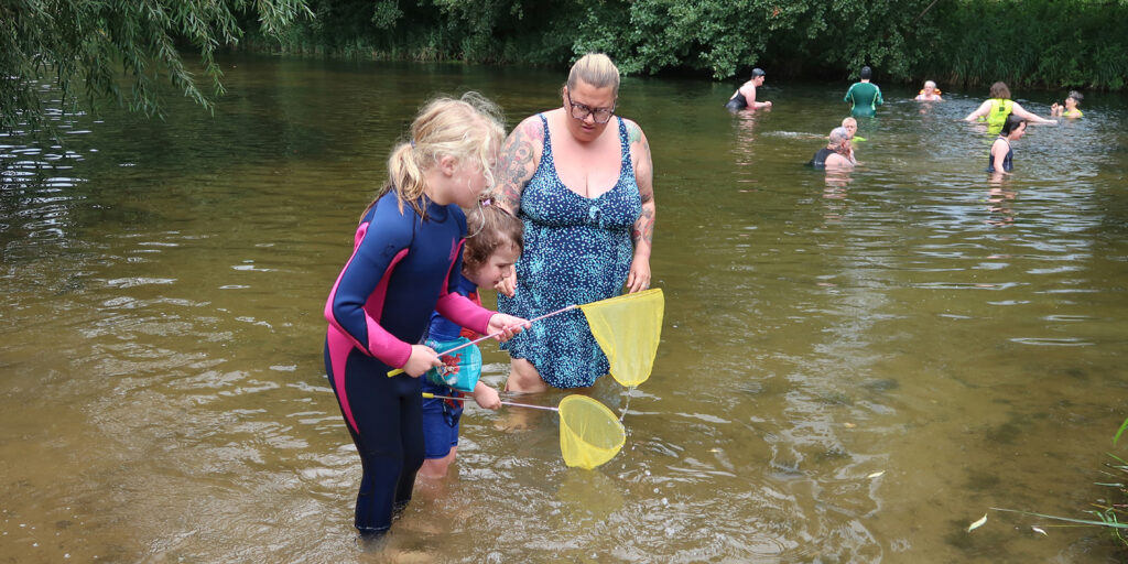 children and parents playing in a river