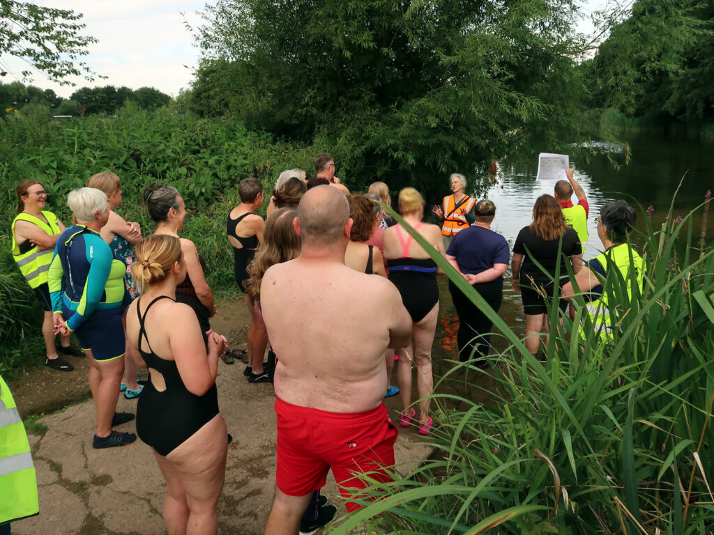swimmers standing for briefing at rivers edge