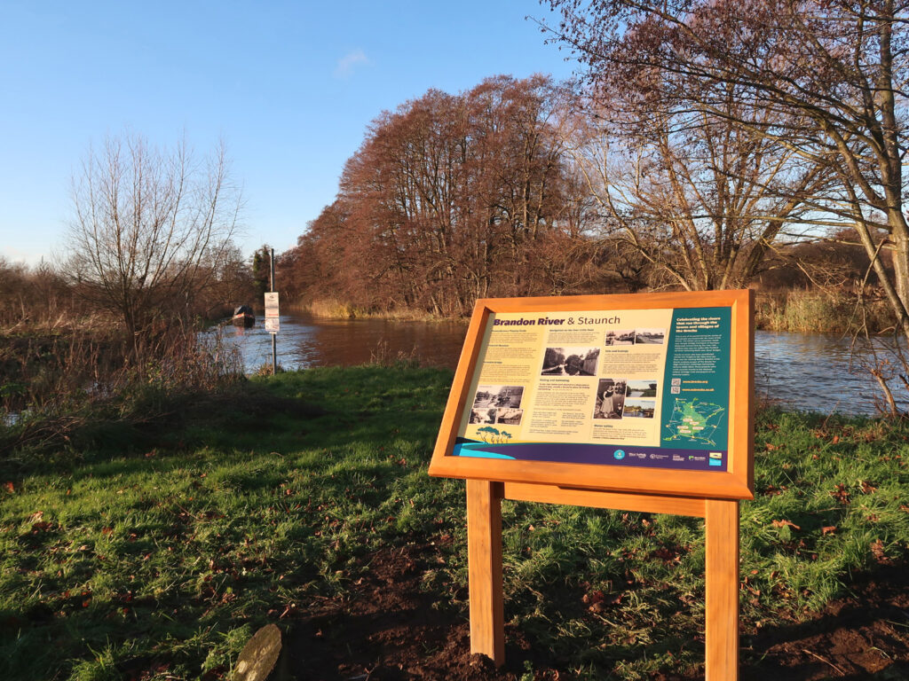 Display panel and river with distant narrowboat autumn colours